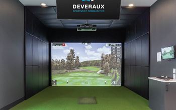 A golf simulator room with a screen showing a golf course.