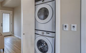 A washing machine is built into the wall in a modern laundry room.