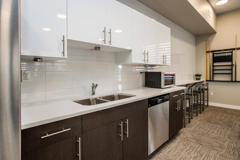 A modern kitchen with white countertops and brown cabinets.