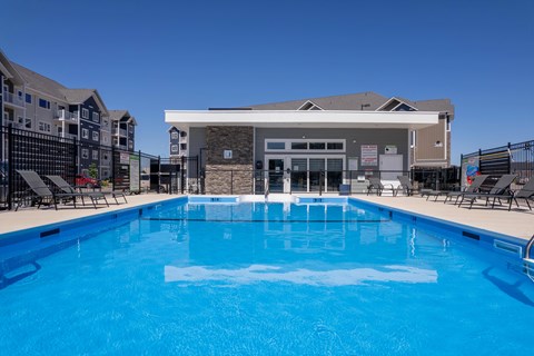 A large blue swimming pool in front of a building.