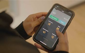 A person holding a phone with a screen displaying a list of options.