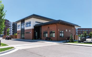 A modern building with a black roof and a sign that reads "SCHOOL" on the front.