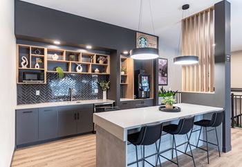 A modern kitchen with a large island and bar stools.