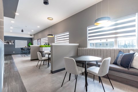 A modern dining area with a table set for four.at Vibe Apartments at Arbour Lake, Alberta, T3G 4J2