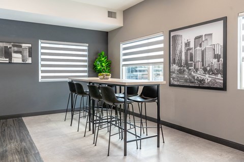 A room with a table and chairs and a picture on the wall.at Vibe Apartments at Arbour Lake, Calgary Alberta