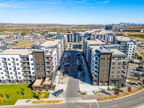 A view of a city from a high vantage point with buildings and a parking lot.