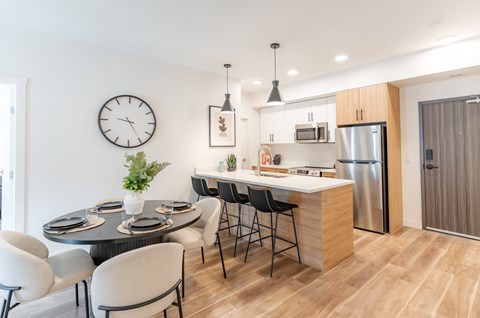 A modern kitchen with a dining table set for four.