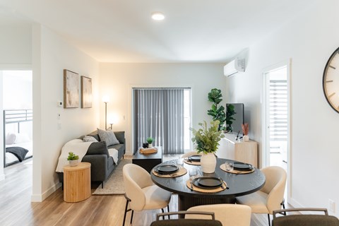 A modern living room with a dining table set for four.