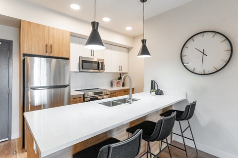A Kitchen With a White Island at Cadence at Griesbach, Edmonton