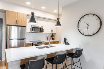 A Kitchen With a Clock On The Wall at Cadence at Griesbach, Alberta, T5E 1Y8