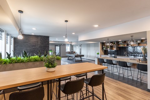 A modern dining area with a long wooden table and chairs.