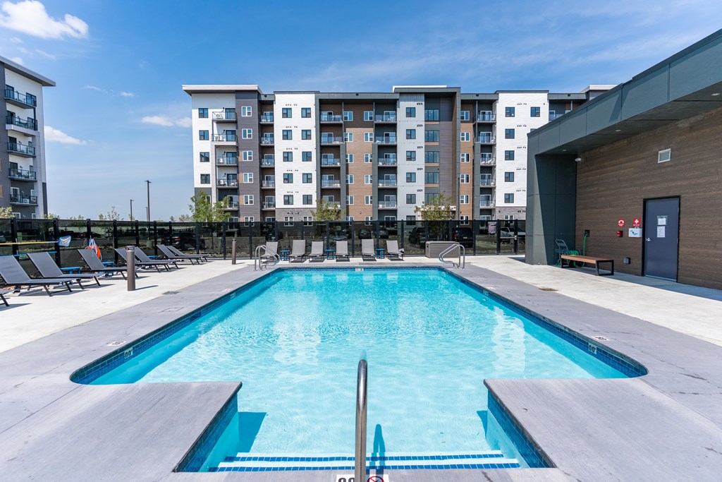 A large swimming pool in front of apartment buildings.