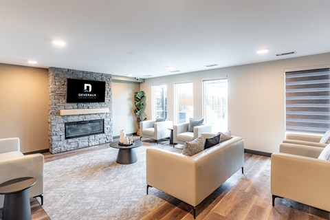A living room with a stone fireplace and a television above it.