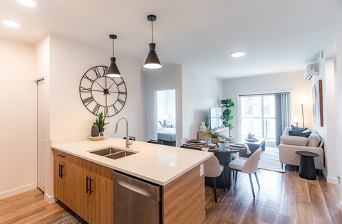 A kitchen with a large island and a dining area with chairs.