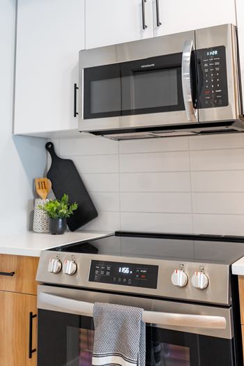 A black microwave oven is mounted above a stove.