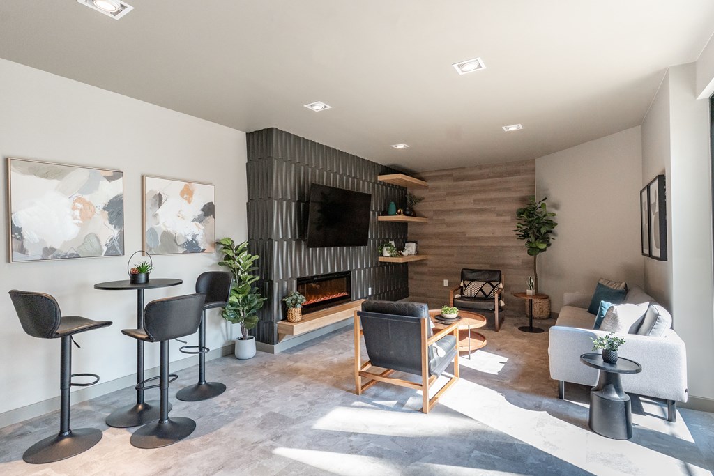 A modern living room with a fireplace and a variety of seating options.