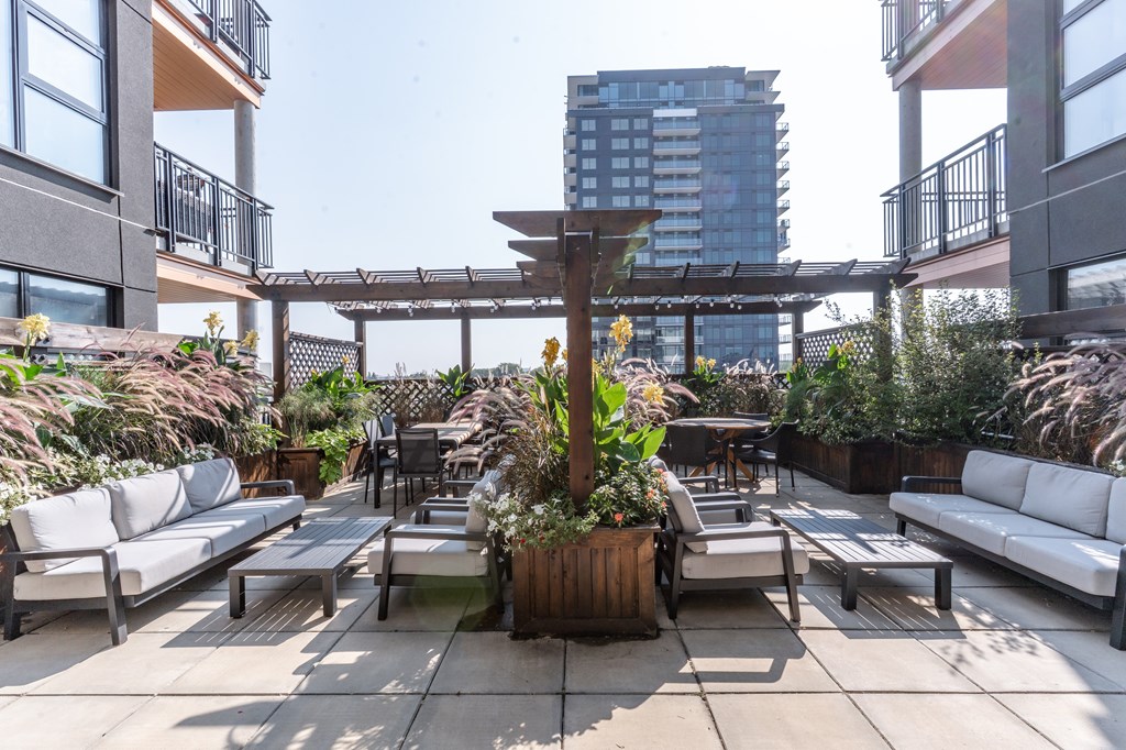 A patio with white couches and a wooden table.
