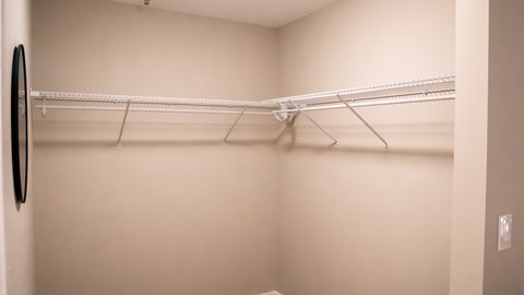 A white closet with a black mirror on the wall.