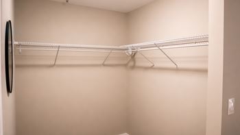 A white closet with a black mirror on the wall.