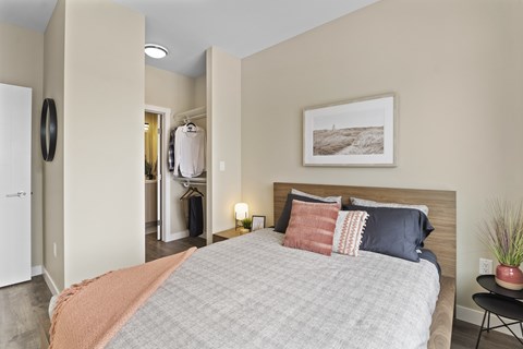 A bedroom with a large bed and a painting on the wall.