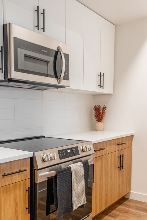 A modern kitchen with a stainless steel microwave above the stove.
