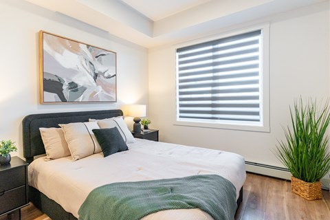 A bedroom with a large bed and a painting on the wall.