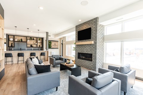 A modern living room with grey couches and a fireplace.
