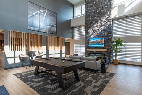 A modern living room with a pool table and a fireplace.