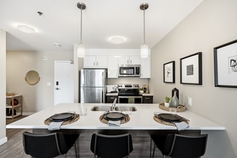 A modern kitchen with a dining table set for four.