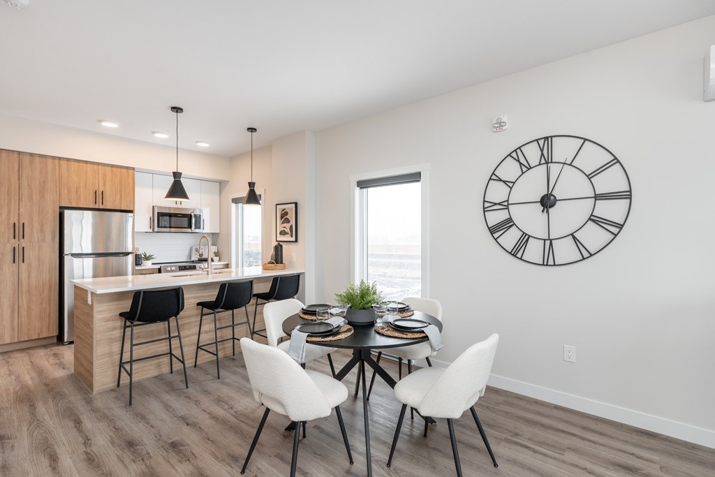 A modern kitchen with a dining table set for four.
