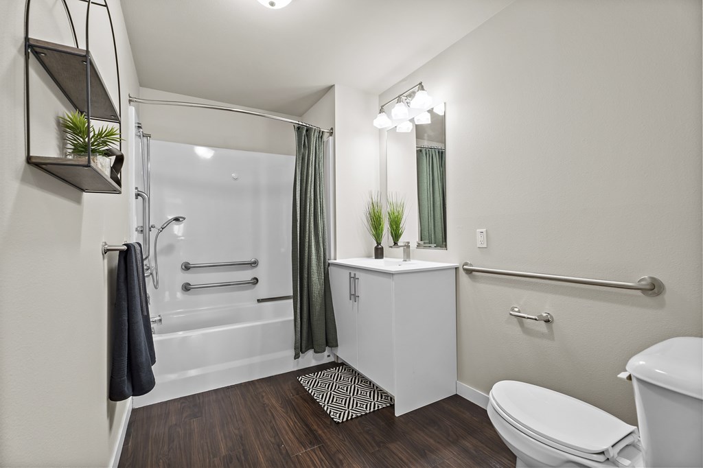 A bathroom with a toilet, sink, and shower.