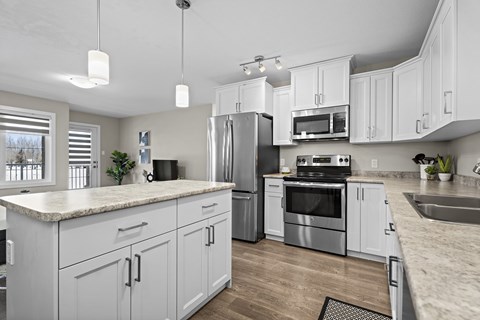 A modern kitchen with stainless steel appliances and white cabinets.