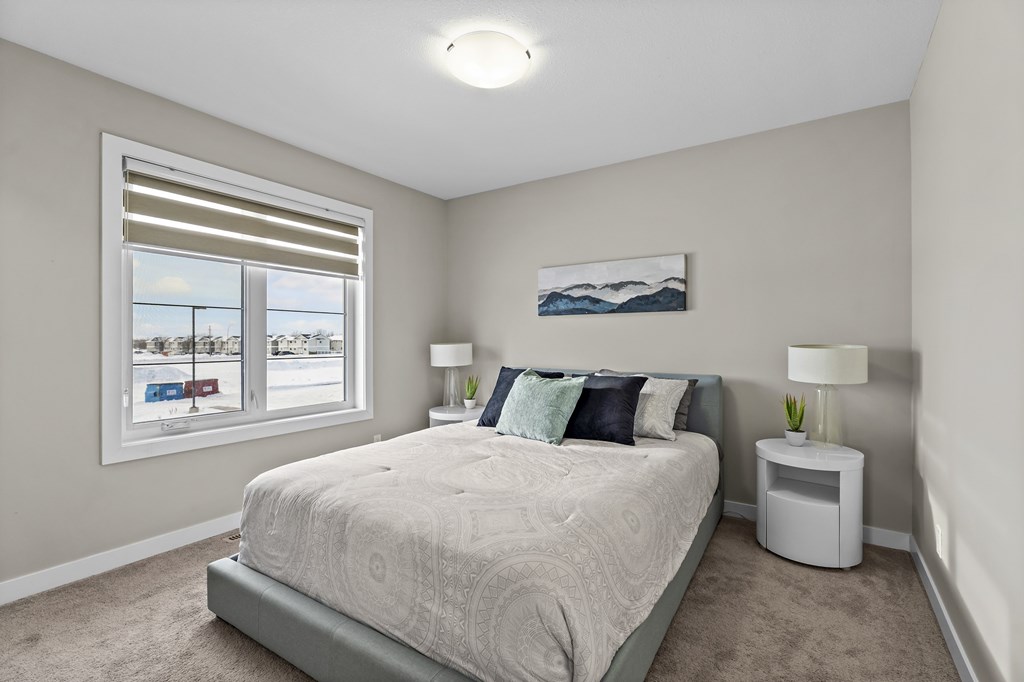 A bedroom with a large bed and a window overlooking a parking lot.