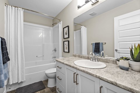 A bathroom with a white toilet, sink, and bathtub.