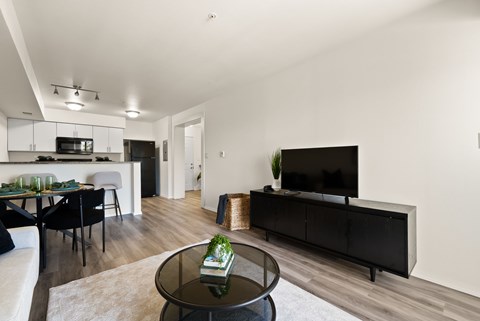 A modern living room with a black coffee table and a flat screen TV.