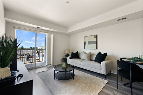 A living room with a couch, coffee table, and sliding glass doors.