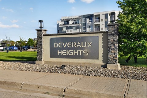 A sign that says Deveraux Heights in front of a building.
