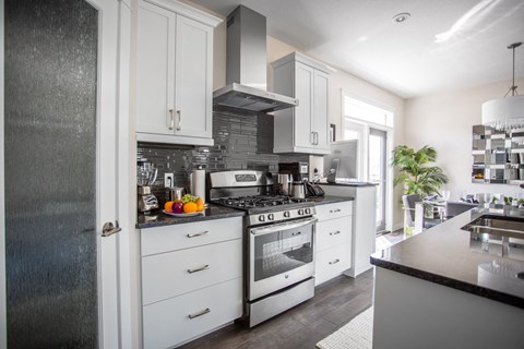 a kitchen with white cabinets and stainless steel appliances