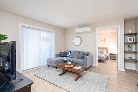 A living room with a grey couch and a wooden coffee table.