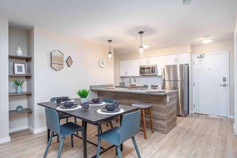 A kitchen with a dining table and chairs.