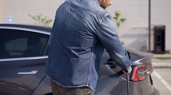 a man refueling his car in a parking lot