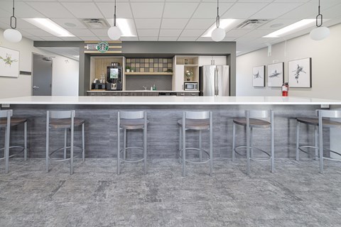 A bar with a counter and stools in front of a Starbucks.