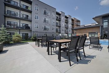 A patio with a table and chairs is in front of a building.