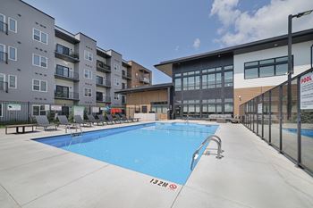 A swimming pool in front of a building with a sign that says "POOL".