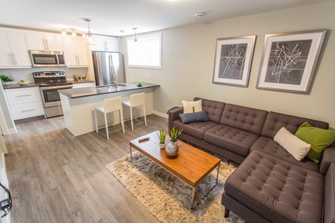A brown couch with a vase on a coffee table in a kitchen.