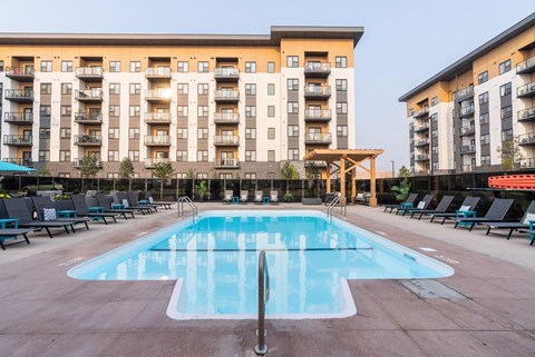 A large swimming pool in front of apartment buildings.