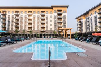 a swimming pool in front of an apartment building at Vibe Apartments at Arbour Lake in Calgary, AB