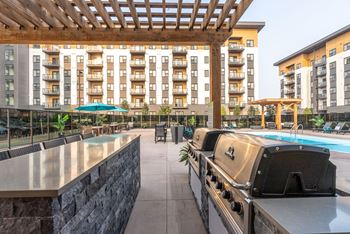 a patio with an outdoor grill and a swimming pool