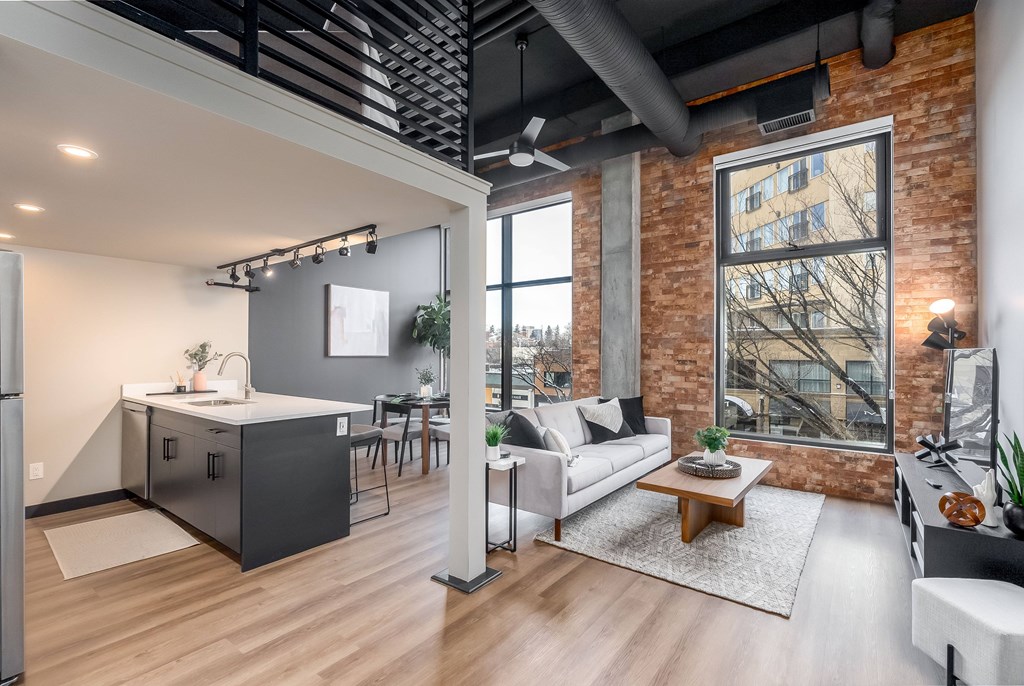 A modern kitchen with a refrigerator, sink, and a dining table with chairs.at Raymond Block, Edmonton