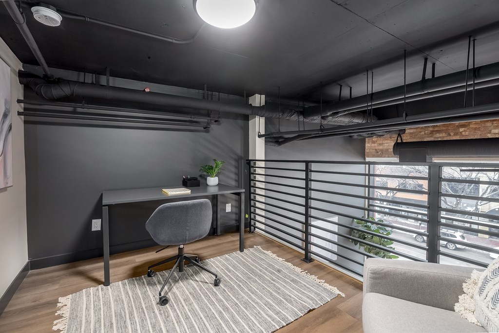 A modern home office with a desk, chair, and a window with blinds.at Raymond Block, Alberta, T6E 3R7